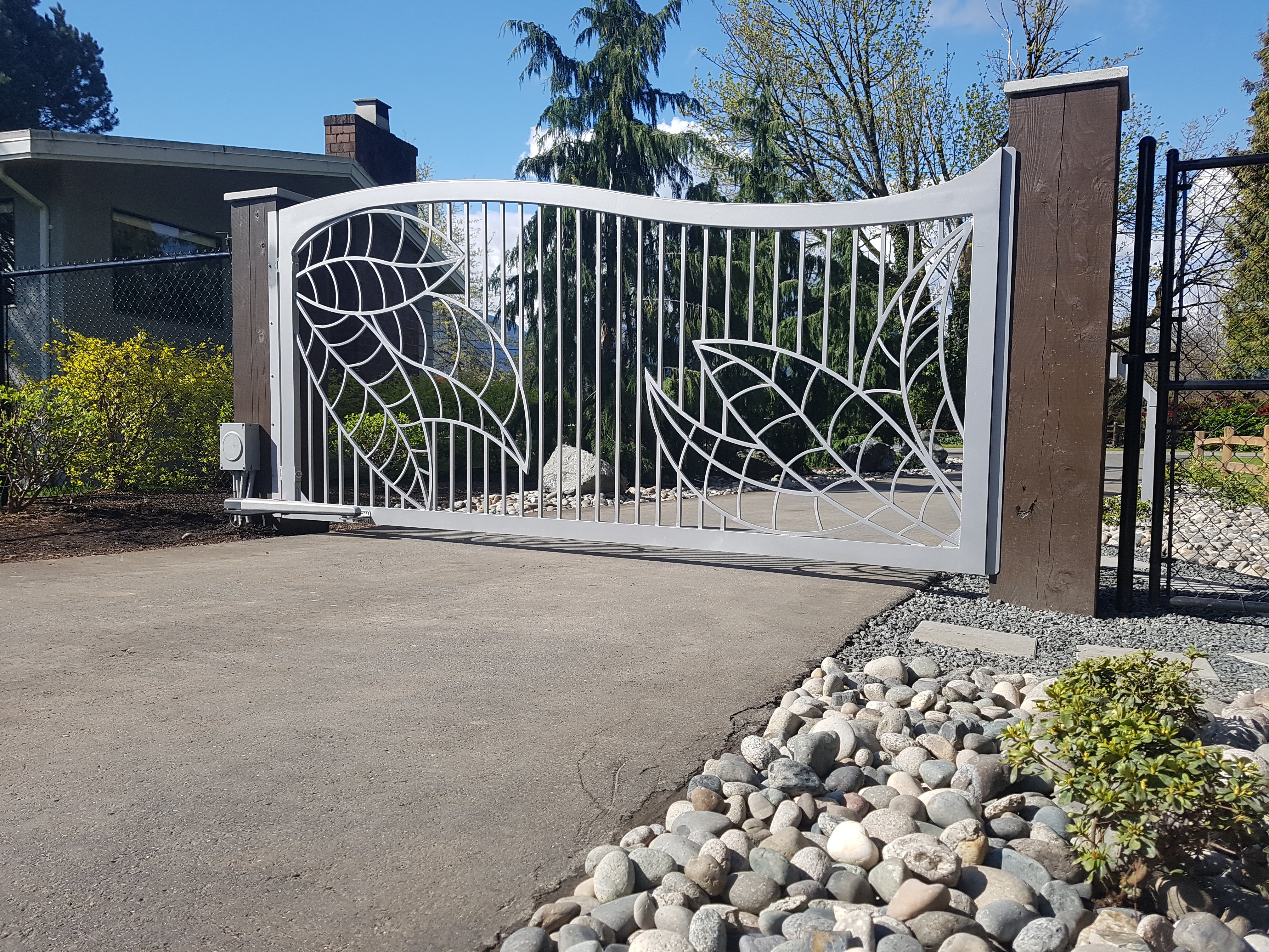 A beautifully arched top gate with custom leaf design fabricated out of aluminium built within the pickets